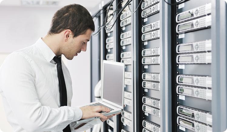 (c) dotshock/Shutterstock.com Mann mit Laptop in einem Serverraum