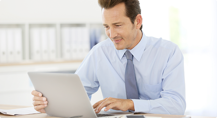 (c) Goodluz/Shutterstock.com Junger Mann im Büro, der auf einem Laptop arbeitet.